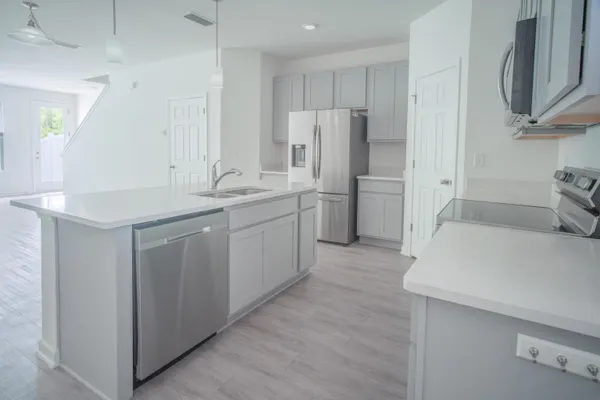 a kitchen with white cabinets and stainless steel appliances