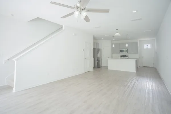 wooden floor in an empty room with a kitchen