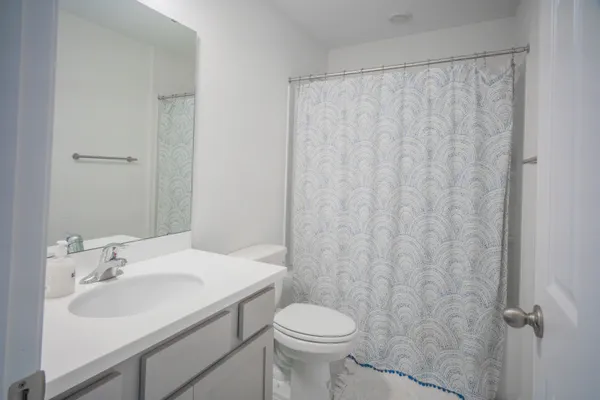 a bathroom with a sink toilet and a mirror