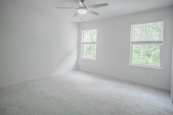 an empty room with a window and a fan