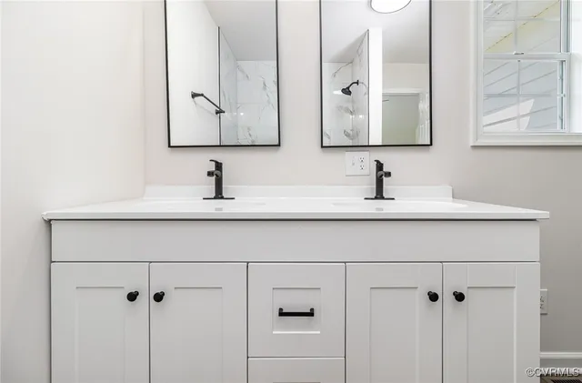 a bathroom with double vanity sink and two mirror