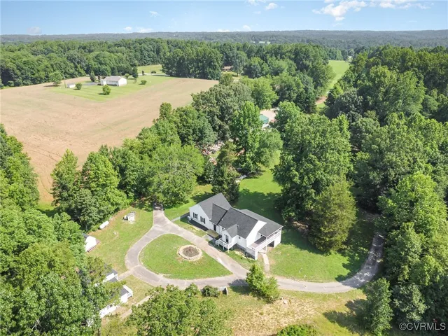 an aerial view of a house with a yard and lake view