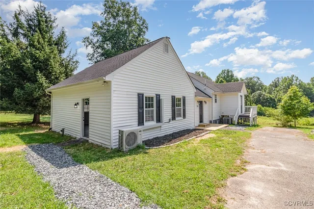 a view of a house with a yard and large tree
