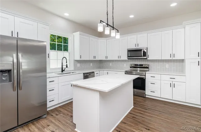 a kitchen with stainless steel appliances cabinets a sink and a center island