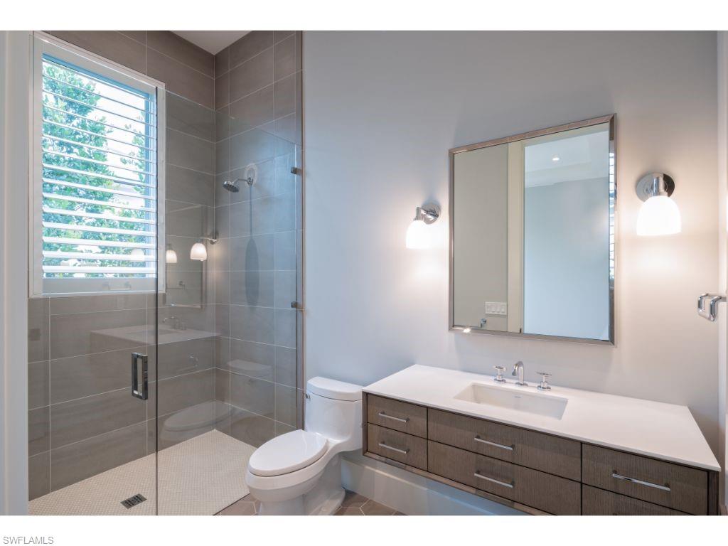 1325 Murex Drive Naples, FL 34102 - Photo 12 of 18 a bathroom with a sink a toilet a mirror and shower