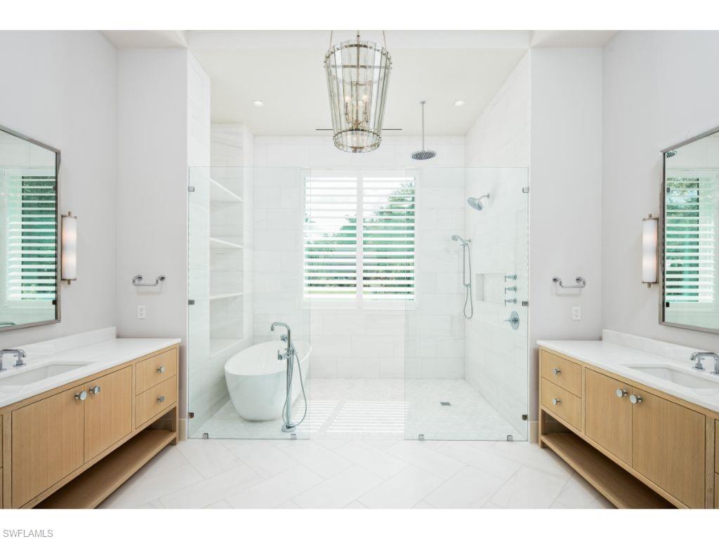 1325 Murex Drive Naples, FL 34102 - Photo 5 of 18 a bathroom with a bathtub sink and a mirror