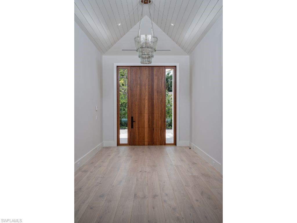 1325 Murex Drive Naples, FL 34102 - Photo 6 of 18 a view of a hallway with wooden floor and chandelier