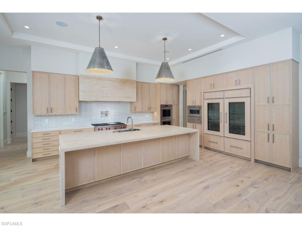 1325 Murex Drive Naples, FL 34102 - Photo 9 of 18 a kitchen with stainless steel appliances granite countertop a sink a stove and a wooden floors