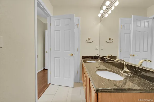 a bathroom with a granite countertop sink a mirror and shower