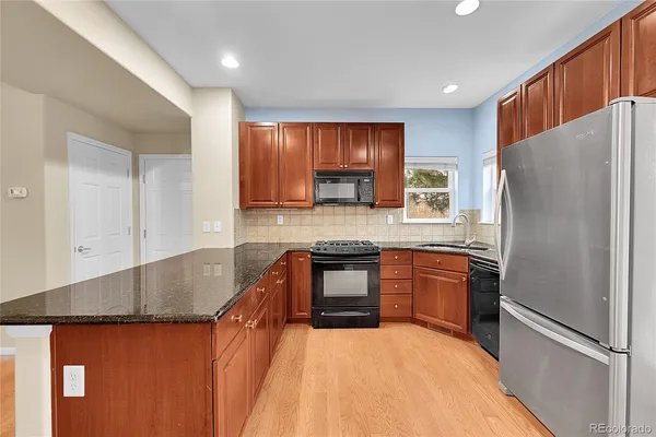 a kitchen with granite countertop a refrigerator and a sink