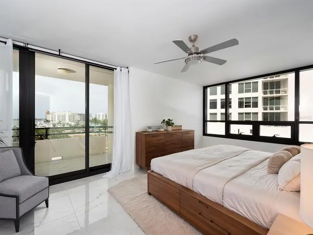 a living room with a black white couch and a potted plant