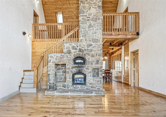 a dining room with wooden floor a chandelier a glass table and chairs