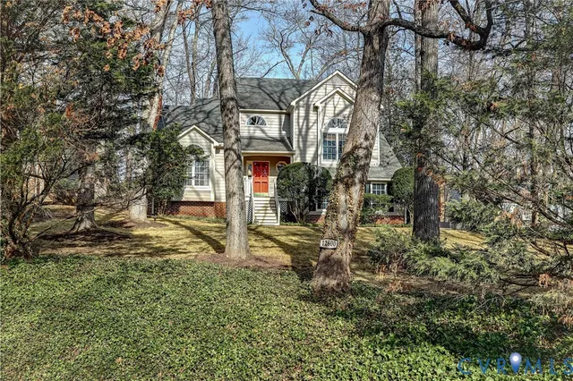 a view of a house with a yard and large tree