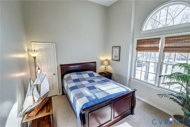 a bedroom with a bed wooden floor and window