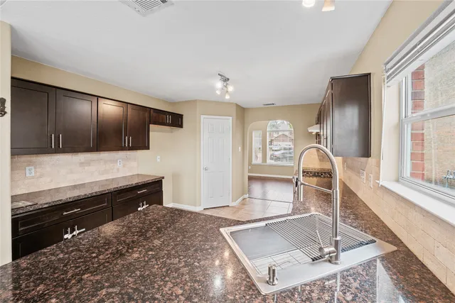 a kitchen with stainless steel appliances kitchen island granite countertop a refrigerator and a stove top oven