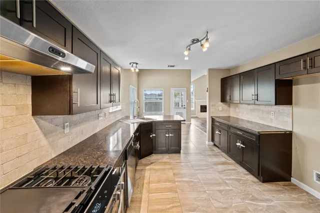 a large kitchen with kitchen island granite countertop a stove and a sink