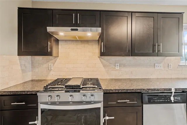 a stove top oven sitting inside of a kitchen