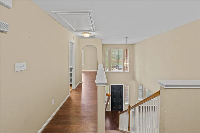 a view of a hallway with wooden floor and staircase