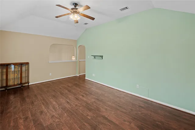 a view of an empty room with window and wooden floor