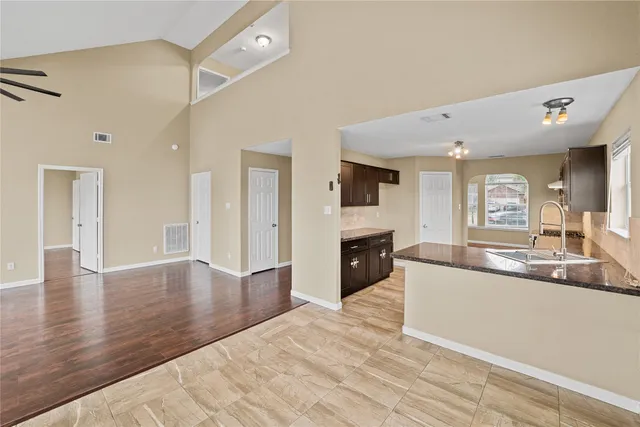 a large white kitchen with granite countertop a sink and dishwasher with a fireplace