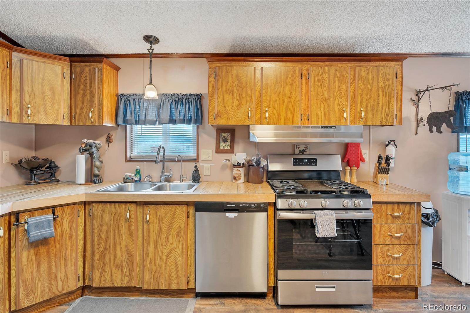 75 6th Street Como, CO 80432 - Photo 11 of 33 a kitchen with a stove a sink and a refrigerator