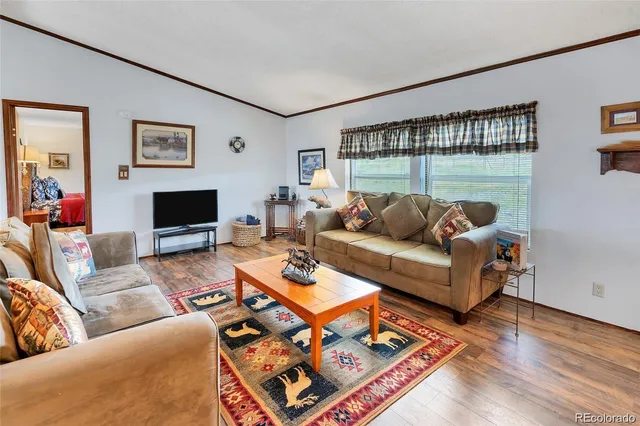 a living room with furniture a flat screen tv and a large window