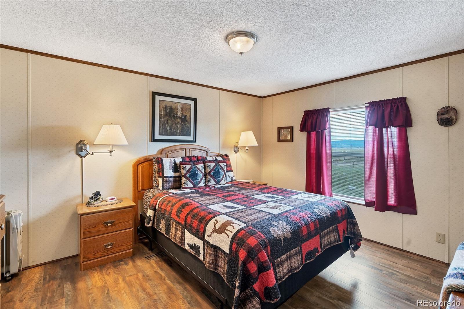 75 6th Street Como, CO 80432 - Photo 20 of 33 a bedroom with a bed and a dresser next to a window