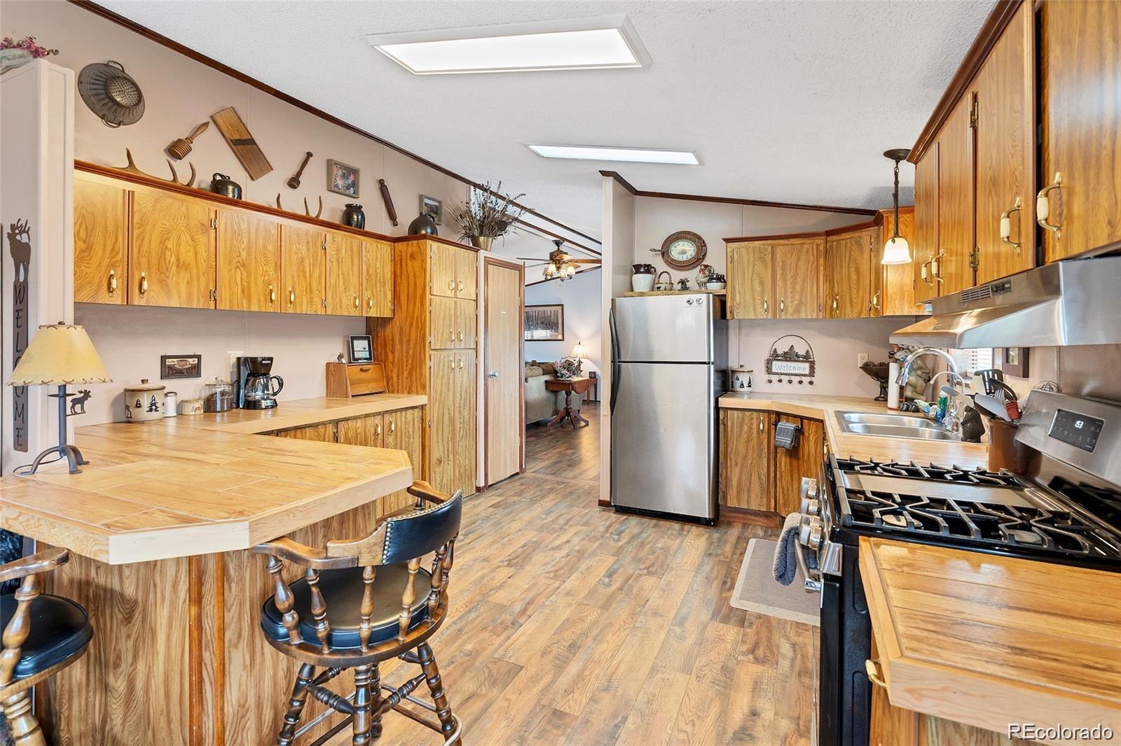 75 6th Street Como, CO 80432 - Photo 4 of 33 a kitchen with stainless steel appliances granite countertop a sink and a refrigerator