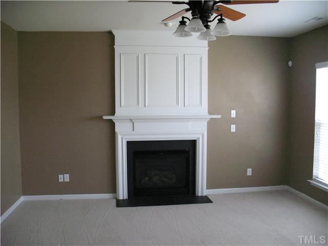 7409 Brandon Allen Avenue Raleigh, NC 27613 - Photo 2 of 14 Living room with gas log fireplace and ceiling fan.