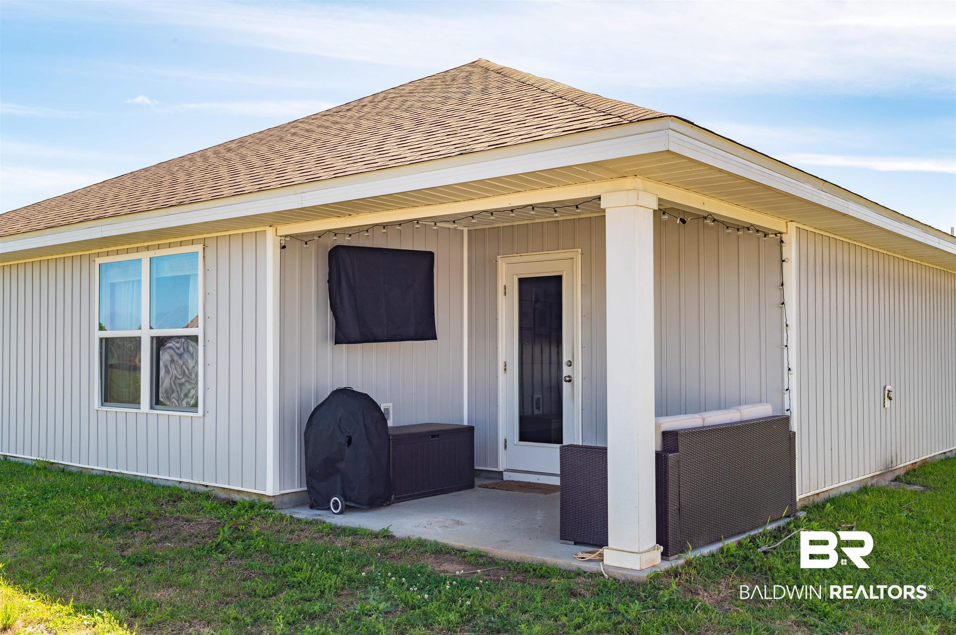 23544 Unbridled Loop Daphne, AL 36526 - Photo 20 of 25 Covered patio with a concrete slab, white vinyl siding, a white column, and a single exterior door