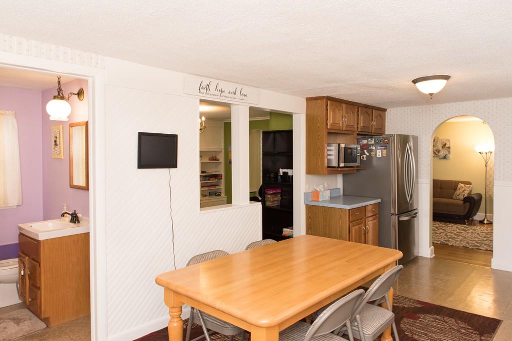 134 Draper Street Springfield, MA 01108 - Photo 9 of 23 a kitchen with stainless steel appliances kitchen island granite countertop a refrigerator a stove top oven and couches with wooden floor