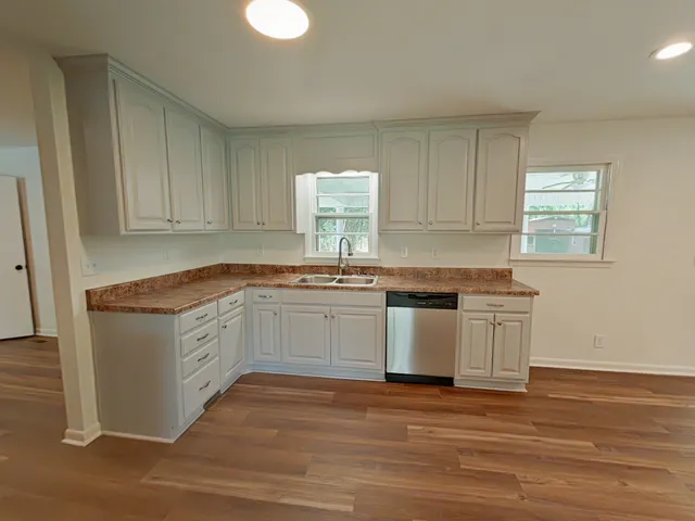 an empty room with wooden floor and windows