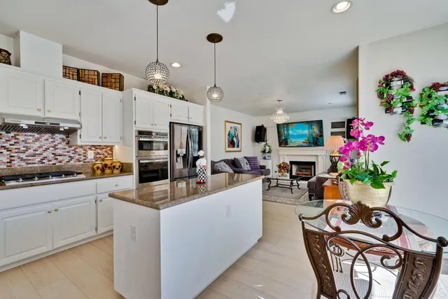 a living room with furniture a chandelier and a fireplace