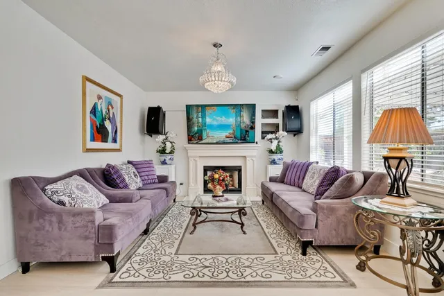 a living room with furniture a flat screen tv and a fireplace