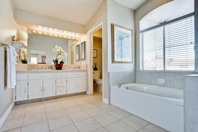 a bedroom with 2 bed and a chandelier