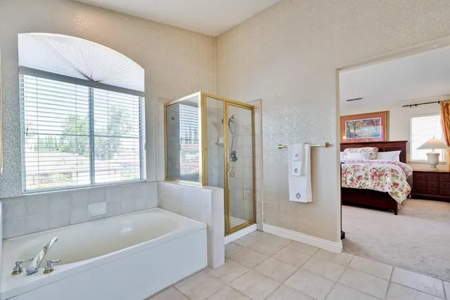 a en suite bathroom with a granite countertop double vanity and a mirror