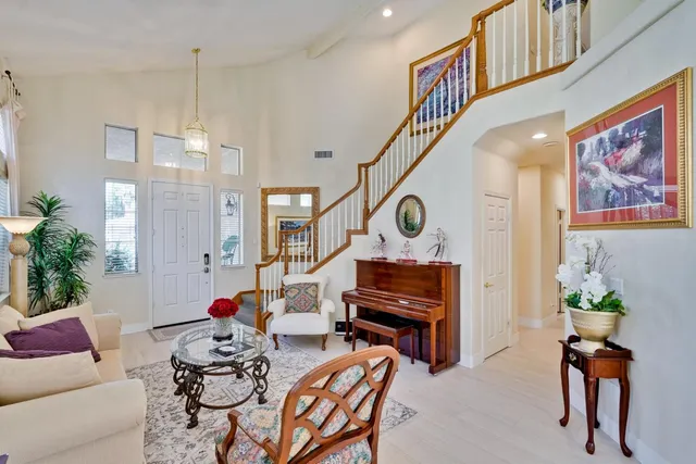 a living room with furniture a piano and wooden floor