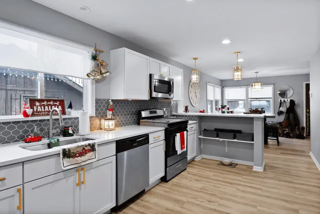 a kitchen with a sink dishwasher and white appliances with wooden floor