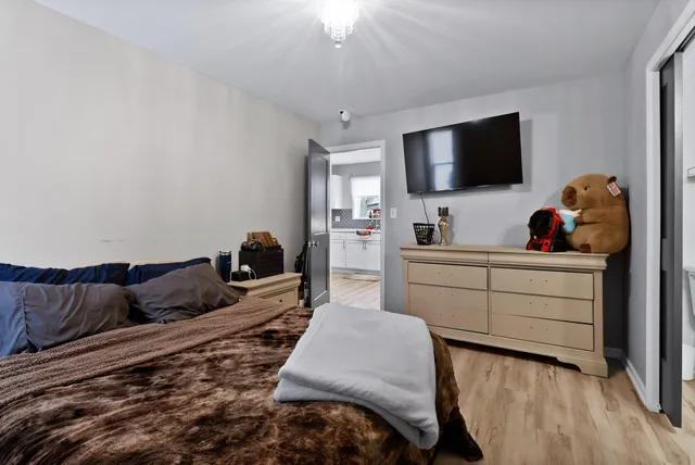 a bedroom with a bed and wooden floor