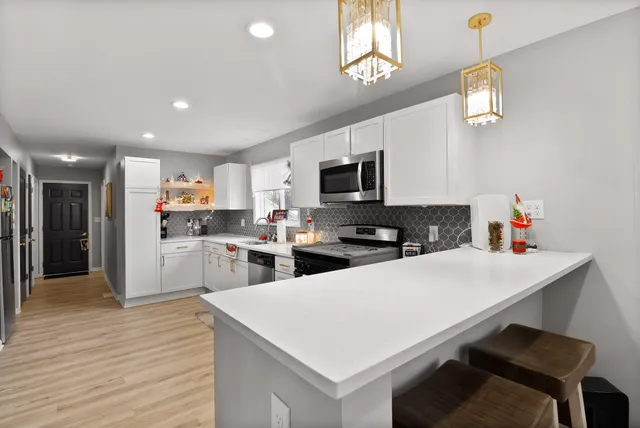 a kitchen with stainless steel appliances cabinets and a window