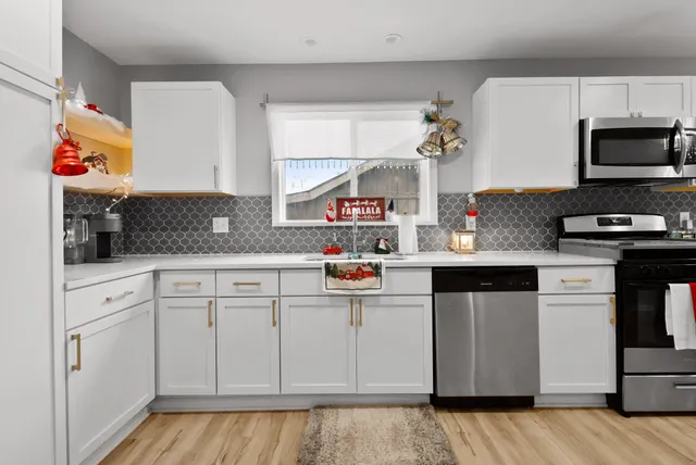 a kitchen with kitchen island a sink cabinets and wooden floor