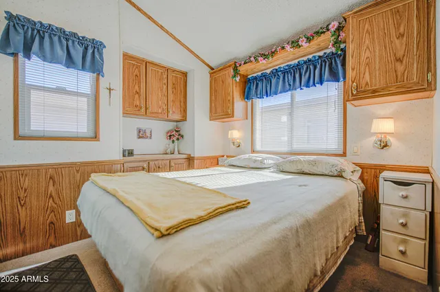 a bedroom with a bed and dresser with mirror