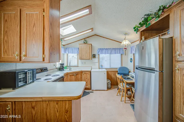 a kitchen with refrigerator a stove a sink and cabinets