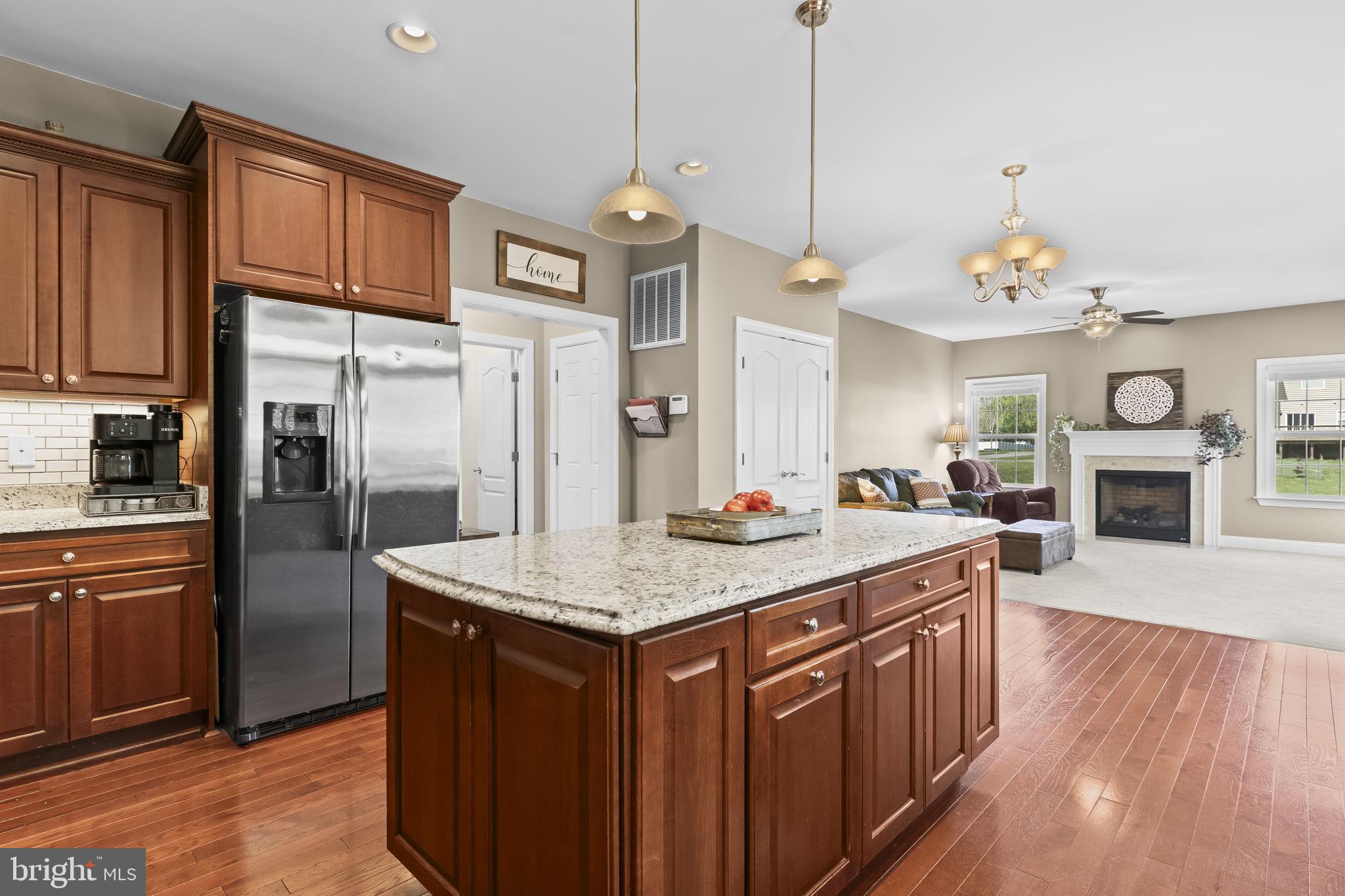 1905 Resting Ridge Lane Prince Frederick, MD 20678 - Photo 11 of 91 a kitchen with stainless steel appliances granite countertop a refrigerator a sink dishwasher a dining table and chairs with wooden floor