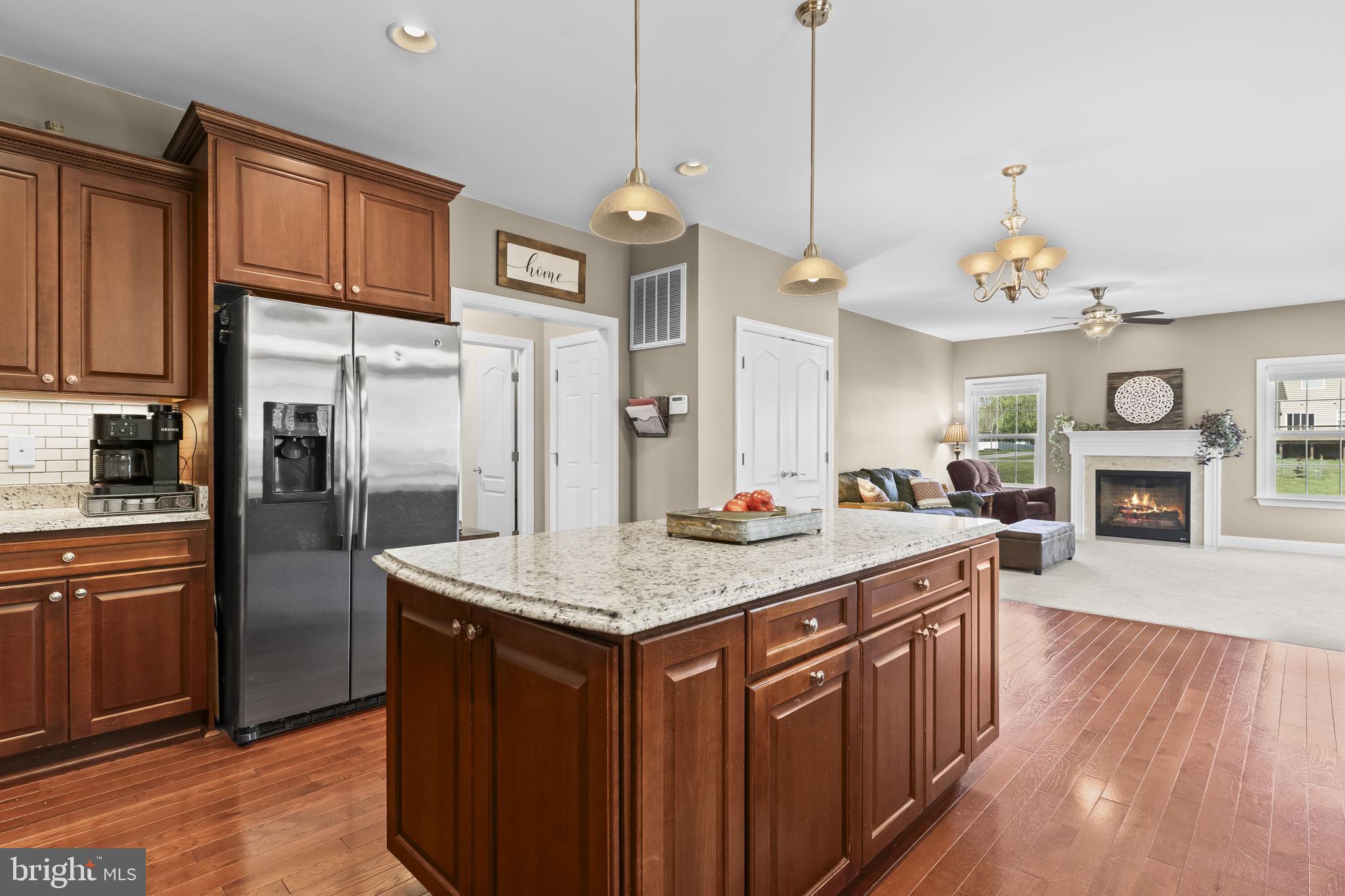1905 Resting Ridge Lane Prince Frederick, MD 20678 - Photo 12 of 91 a kitchen with stainless steel appliances granite countertop a refrigerator a sink dishwasher a dining table and chairs with wooden floor