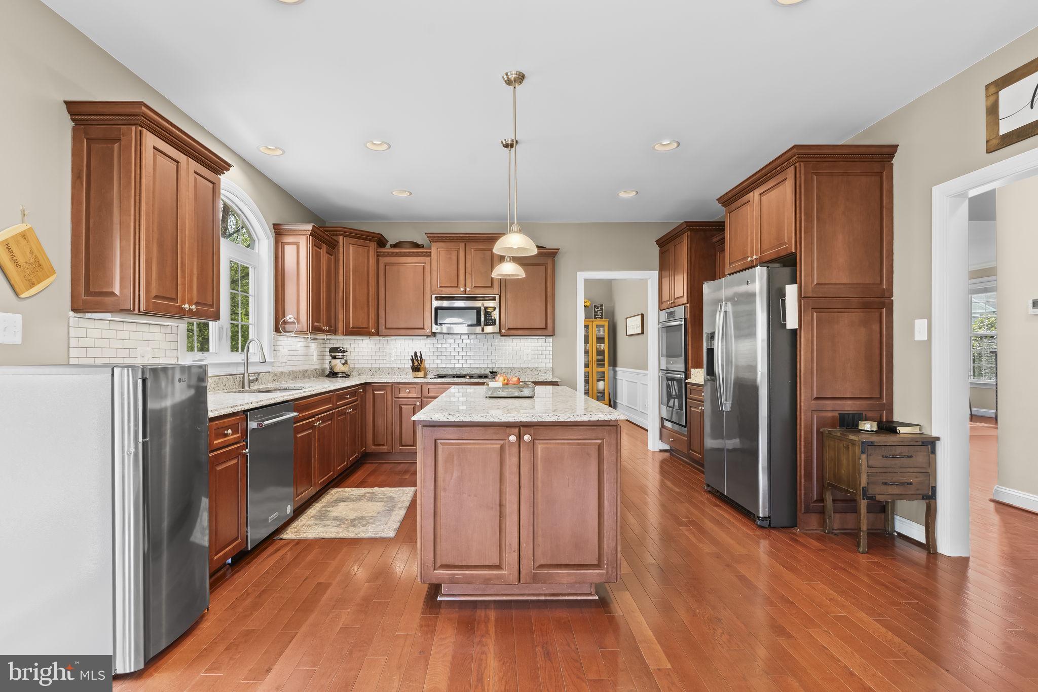 1905 Resting Ridge Lane Prince Frederick, MD 20678 - Photo 13 of 91 a large kitchen with stainless steel appliances wooden floors and wooden cabinets
