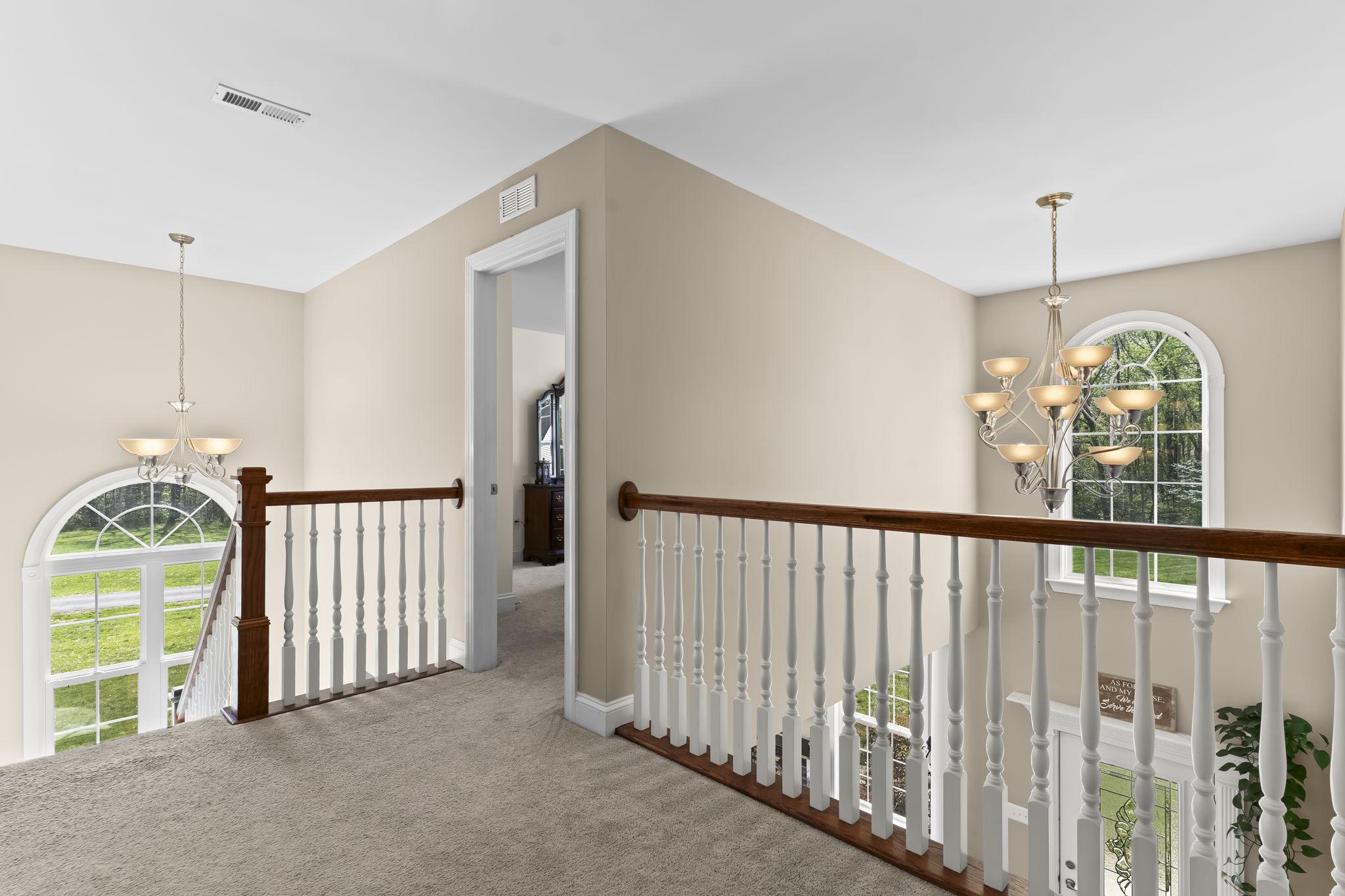 1905 Resting Ridge Lane Prince Frederick, MD 20678 - Photo 29 of 91 a view of a hallway to a livingroom with furniture and stairs