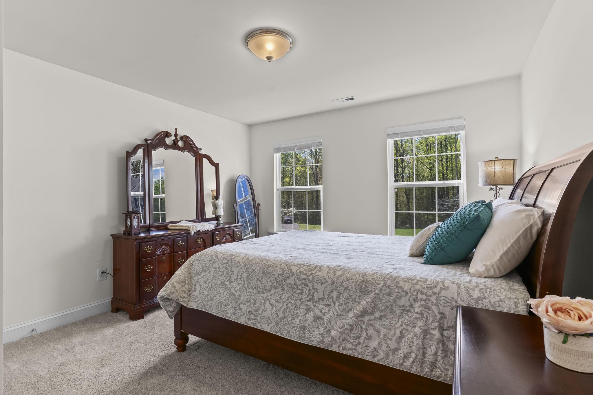 1905 Resting Ridge Lane Prince Frederick, MD 20678 - Photo 39 of 91 a bedroom with a bed a large mirror on dresser and a large window