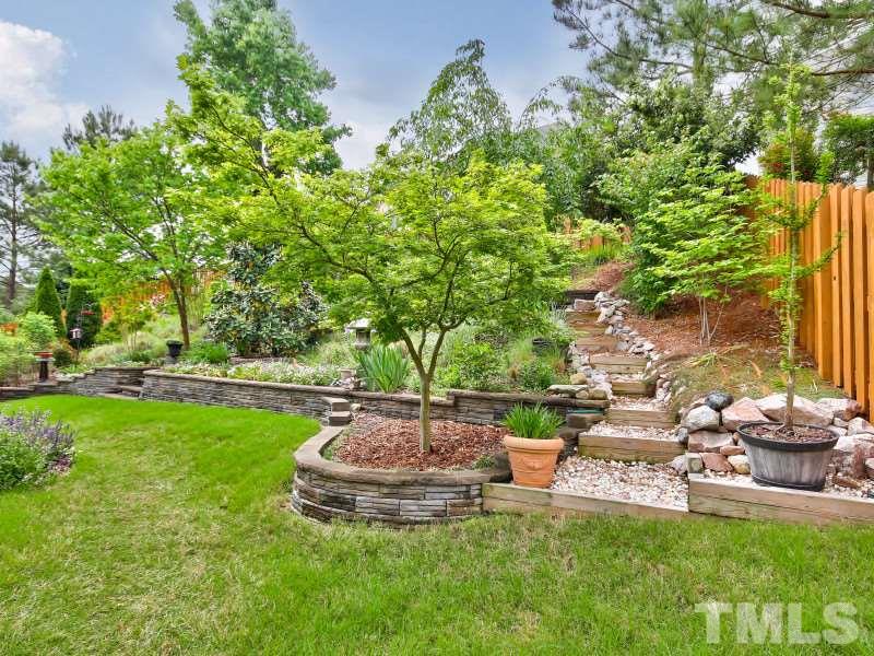 5304 Jade Forest Trail Raleigh, NC 27616 - Photo 3 of 22 a view of a backyard with table and chairs potted plants and large tree