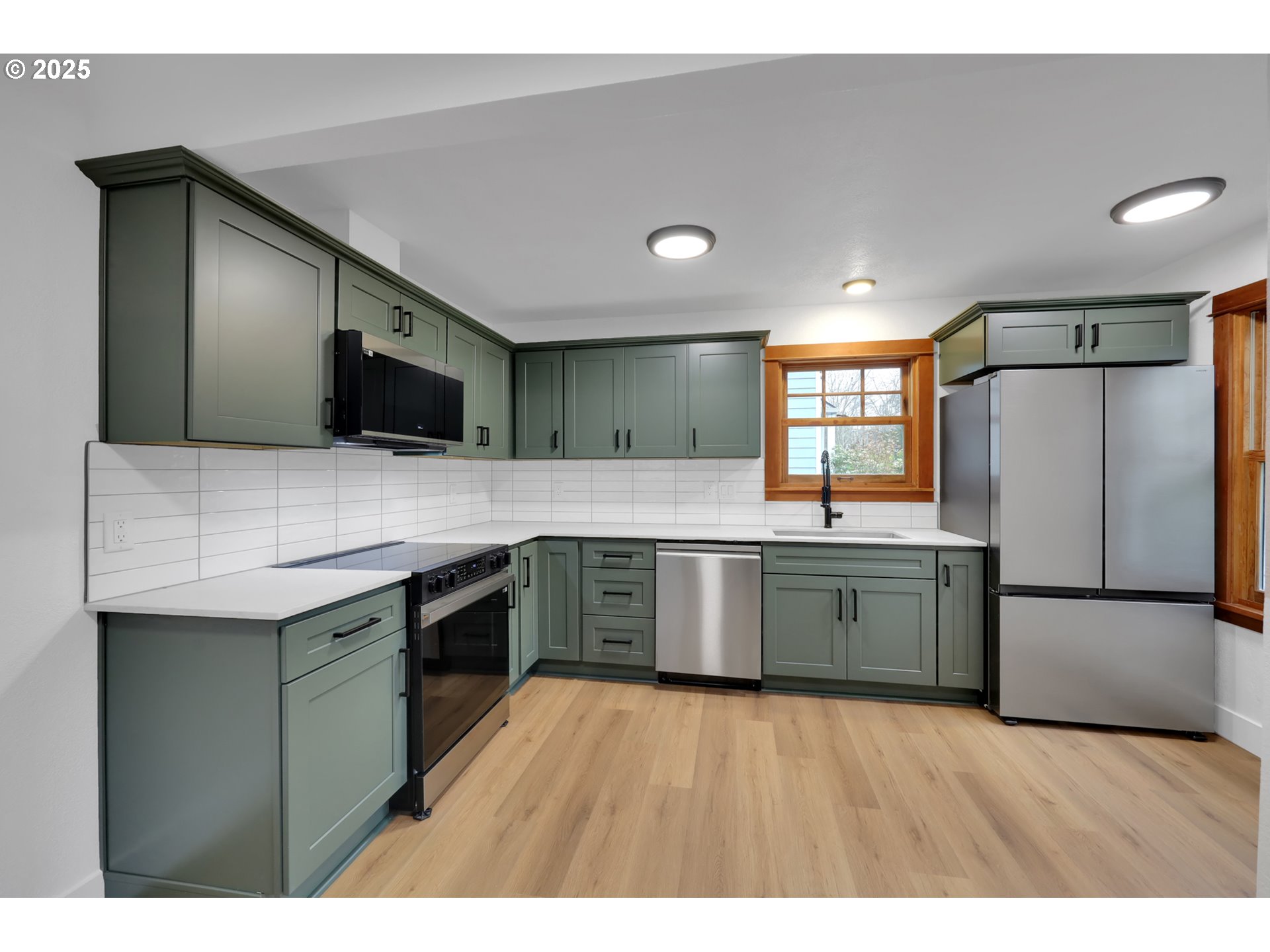 2121 Jefferson Street Eugene, OR 97405 - Photo 13 of 35 a kitchen with stainless steel appliances granite countertop a sink a stove top oven and wooden floors